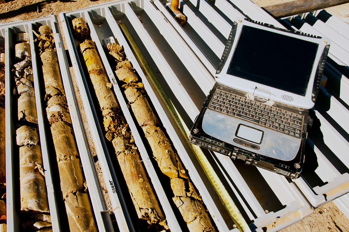 Carottes de minerai à côté d’un ordinateur portable de géologue, départ et arrivée de l’infrastructure numérique
